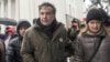Former Georgian president Mikheil Saakashvili, left, and his wife Sandra Roelofs, right, attend a rally of his supporters as they camp out outside parliament demanding the resignation of the Ukrainian president, in Kiev, Ukraine, Dec. 6, 2017.