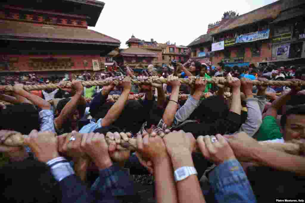 Umat Hindu menarik tali yang diikat pada kereta Dewa Hindu 'Bhairab', melalui pusat kota Bhaktapur dekat Kathmandu, Nepal, selama berlangsungnya festival keagamaan Bisket.