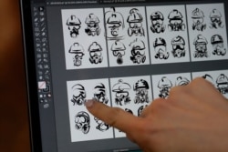 A client who goes by the single name Mary chooses a tattoo image depicting protective gear-wearing protesters from a computer display in Hong Kong, Oct. 23, 2019.