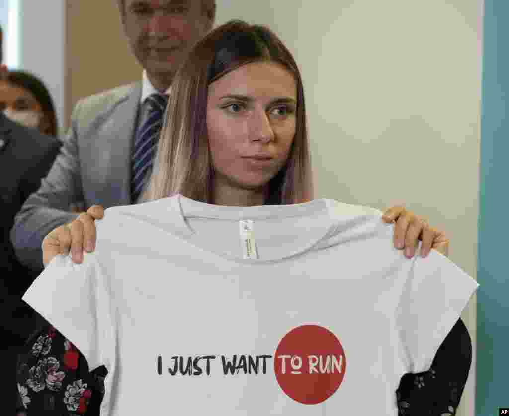 Belarusian Olympic sprinter Krystsina Tsimanouskaya shows an Olympic-related T-shirt with her slogan "I Just Want to Run" after her news conference in Warsaw, Poland. Tsimanouskaya came to Poland, fearing reprisals at home after criticizing her coaches at the Tokyo Games.