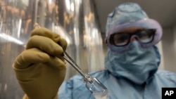 Sebuah vial vaksin COVID-19 buatan Kuba bernama “Soberana 02” di pabrik pengolahan kemasan Finlay Vaccine Institute di Havana, Kuba, Rabu, 20 Januari 2021. (Foto: AP)