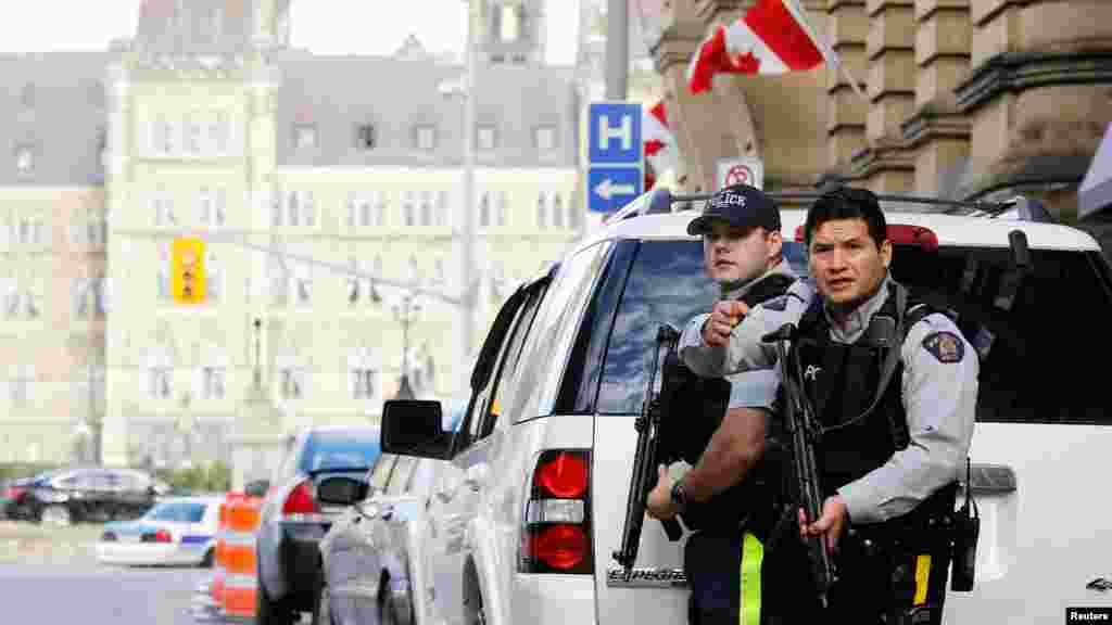 Armed Royal Canadian Mounted Police officers guard access to Parliament Hill following a shooting incident in Ottawa, Oct. 22, 2014.