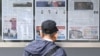 Кореец читает газету, в которой рассказывается о решении Северной Кореи направить тысячи солдат на передовую линию обороны Украины (архивное фото)