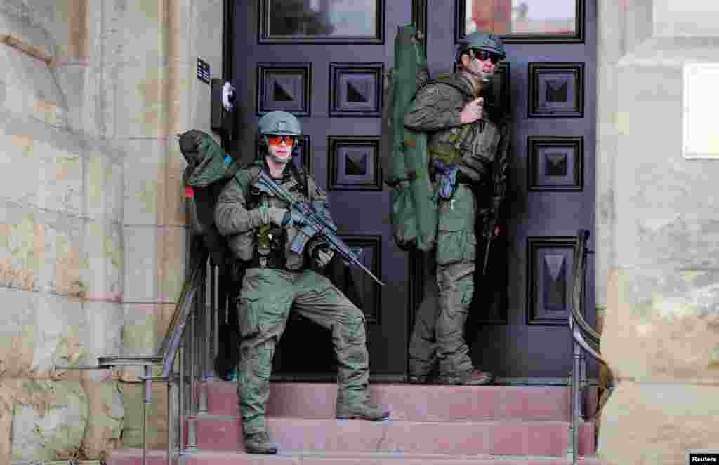 Armed RCMP officers guard the front of Langevin Block on Parliament Hilll following a shooting incident in Ottawa.