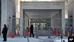 Un agente de seguridad camina frente a la entrada de la oficina central de la Agencia de Alcohol, Tabaco, Armas de Fuego y Explosivos de Estados Unidos, el 23 de enero de 2014, en Washington. 