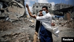 Binh sĩ cứu thương giúp một người Palestine bị thương trong vụ không kích của Israel tại Shejaia, thành phố Gaza, ngày 20/7/2014.