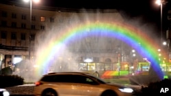 Cars drive past a light-and-water rainbow installation on the night before a gay pride parade, in downtown Warsaw, Poland, June 8, 2018. A conservative turn in Poland has made the fight for gay rights all the more difficult.