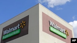 This Feb. 8, 2017, photo shows Wal-Mart signage at one of the company's neighborhood markets, in Hialeah, Florida.