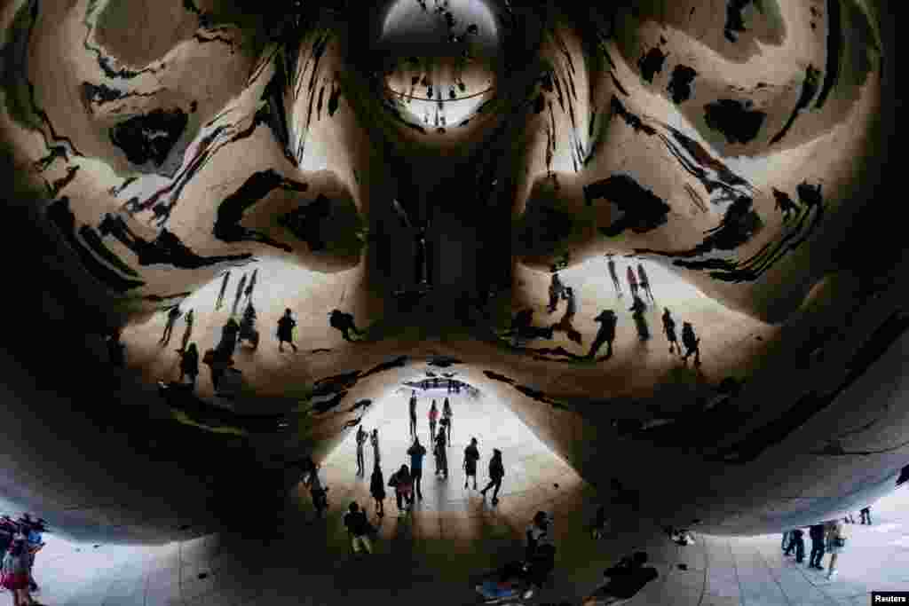 People spend time at the Cloud Gate sculpture in Millennium Park in Chicago, Illinois, Sept. 5, 2021.