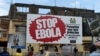 FILES - People walking past a billboard reading "Stop Ebola" in Freetown, Sierra Leone, Nov. 7, 2014. 