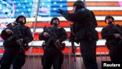 Oficiales de policía de la división de operación especial Grupo de Respuesta Estratégica vigilan en Time Square en Nueva York, el sábado, 14 de noviembre de 2015, tras los ataques en París.

