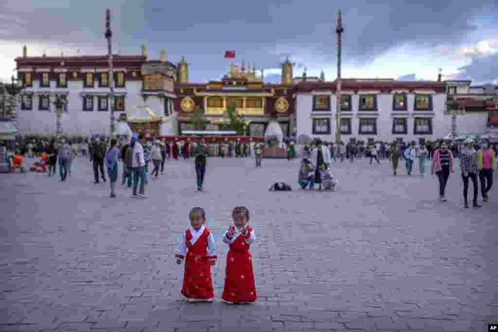 Girls stand on a square in front of the Jokhang Temple in Lhasa in western China's Tibet Autonomous Region during a government organized visit for foreign journalists.