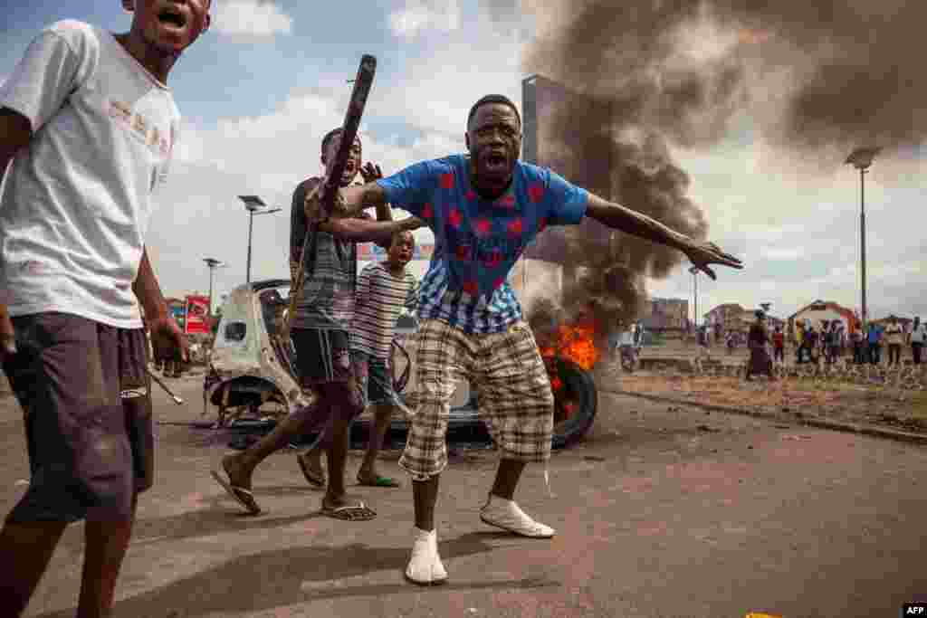 Demonstrators gather in front of a burning car during an opposition rally in Kinshasa, DRC. Police fired tear gas at scores of opposition supporters rallying in Kinshasa to demand that the country's long-serving President Joseph Kabila step down this year.