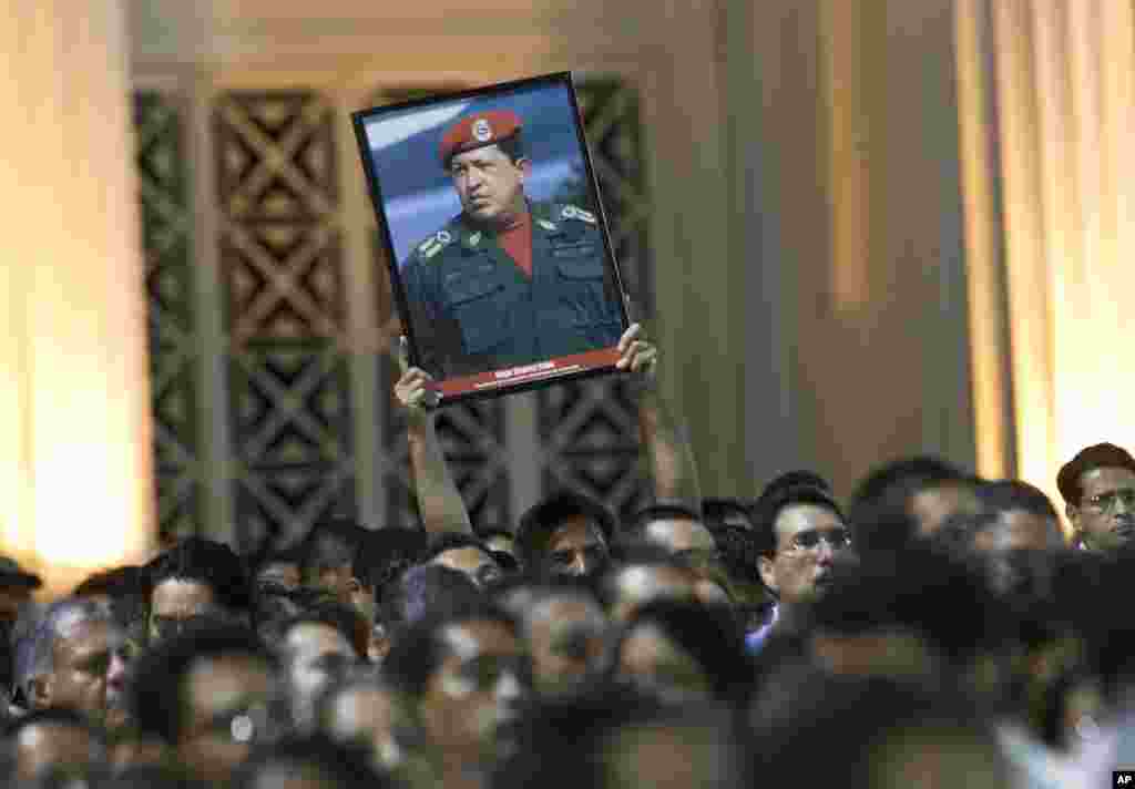 Một người đàn ông cầm hình Tổng thống Venezuela Hugo Chavez trong một cuộc biểu tình ở Managua, Nicaragua, ngày 5/3/2013.