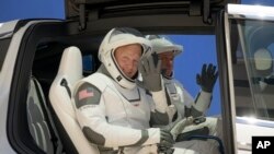 NASA astronauts Douglas Hurley, left, and Robert Behnken, wearing SpaceX spacesuits, depart the Neil A. Armstrong Operations and Checkout Building for Launch Complex 39A during a dress rehearsal prior to the Demo-2 mission launch, Saturday, May 23,…