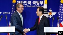 El secretario de Defensa de EE.UU., Ash Carter (izquierda) estrecha la mano del ministro de Defensa surcoreano, Han Min Koo, durante una conferencia de prensa conjunta el lunes, 2 de noviembre de 2015, en Seúl.
