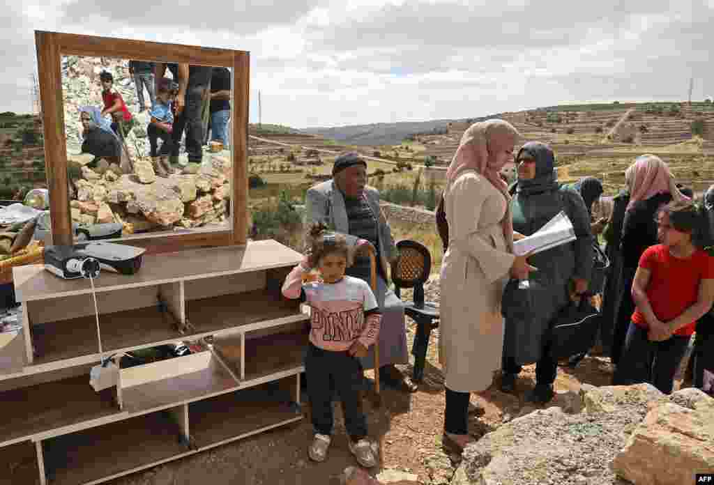 Members of a Palestinian family check their belongings after Israeli machinery demolished their house located in the "Area C" of the occupied West Bank, where Israel retains full control over planning and construction, near the village of Halhoul, north of Hebron.
