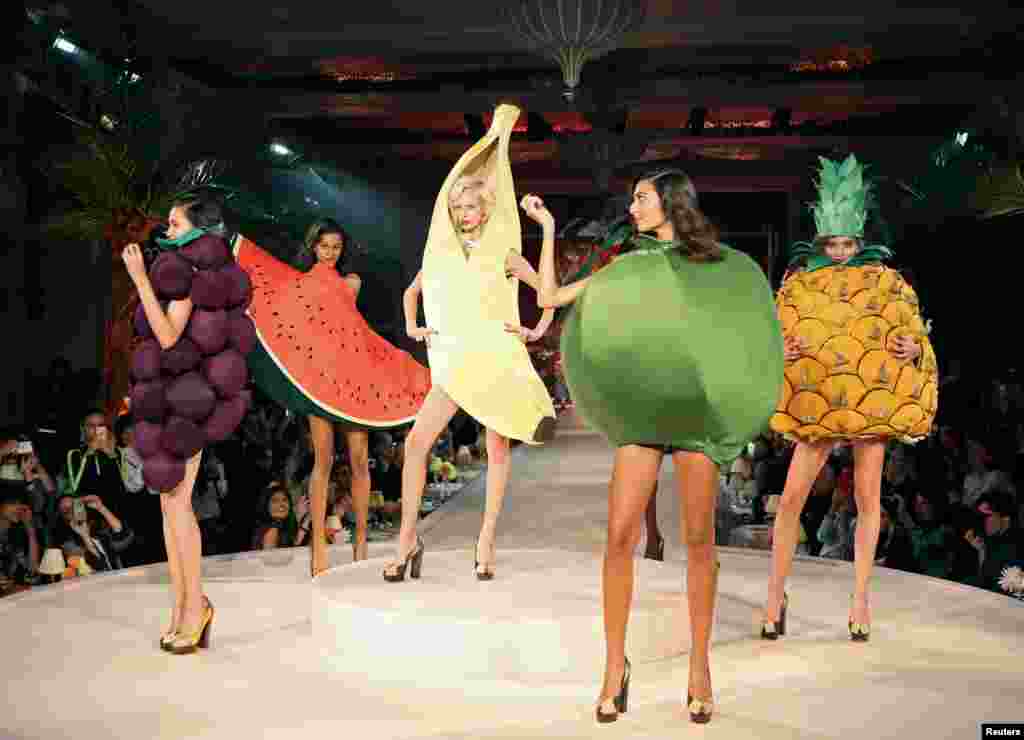 Para model mengenakan kreasi busana yang berbentuk buah-buahan pada London Fashion Week di London, Inggris.
