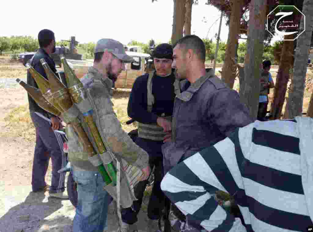 This citizen journalism image provided by Qusair Lens shows rebels preparing to repel an attack by government forces, in Qusair, Homs province, Syria, May 19, 2013.