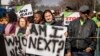 Women protest outside the Krugersdorp, South Africa, Magistrates Court, Aug. 1, 2022. More than 80 men suspected of the gang rapes of eight women and armed robbery of a video production crew appeared in court Monday.