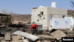  An aid worker searches the wreckage at the scene of an air strike that hit a gas station near a hospital in Kutaf district of the northwestern province of Saada, Yemen, March 28, 2019. REUTERS/Naif Rahma 