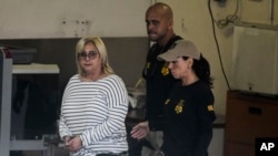 Federal agents escort former Puerto Rico Health Insurance Administration head Ángela Ávila-Marrero who was arrested in San Juan, Puerto Rico, July 10, 2019. 