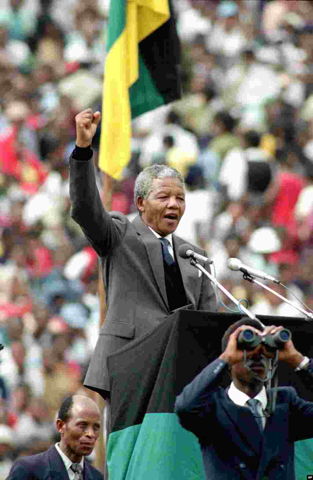 Ông Mandela, Lãnh tụ đảng ANC và là biểu tượng của cuộc kháng chiến chống chủ nghĩa phân chủng apartheid, chào theo kiểu chứng tỏ sức mạnh của người da đen, trước 120.000 thành viên ANC tụ tập tại sân vận động Soweto, Nam Phi, 13/2/1990.