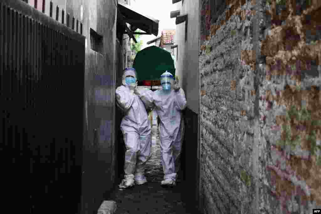 Health workers remove the body of a man who died of Covid-19 coronavirus at his Home in Bandung as Indonesia’s infection rates soar and hospitals are flooded with new patients, prompting warnings that the Southeast Asian nation's health crisis could spiral out of control.