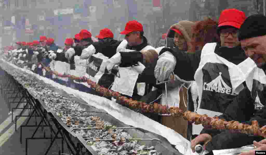 Warga di Kiev, Ukraina, memanggang shashlik raksasa yang panjangnya 150 meter. Para peserta kontes itu memecahkan rekor nasional memanggang shashlik terpanjang. Shashlik adalah sejenis satai daging yang umumnya disantap di kawasan negara-negara yang dulu tergabung dalam Uni Sovyet.