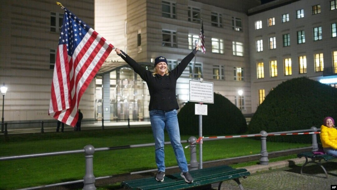 Marijen Henau iz američke države Konektikat proslavlja pobedu Džoa Bajdena i Kamale Haris ispred američke ambasade u Berlinu, pored Brandenburške kapije, 7. novembra 2020. (Foto: AP)